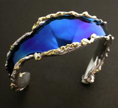 Titanium bangle with fused metal